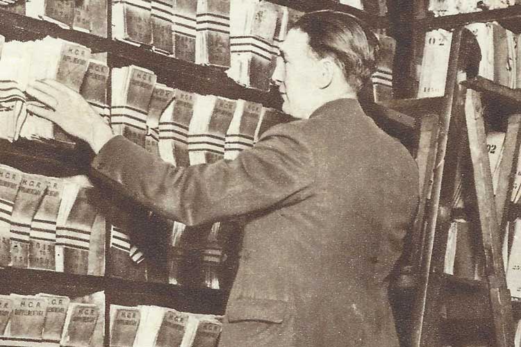 A man looking at shelves of records.