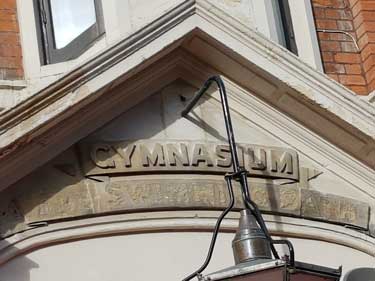 The carved Gynasium and Swimming Pool sign over the left door.